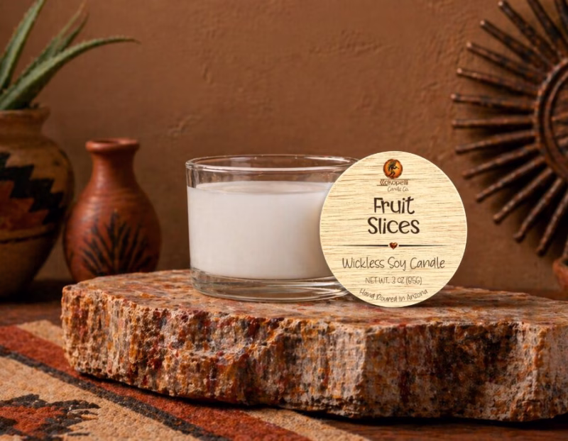 3 oz Fruit Slices wickless soy candle displayed on a natural stone pedestal with warm Southwest décor, handcrafted by Kokopelli Candle Co. in Arizona.