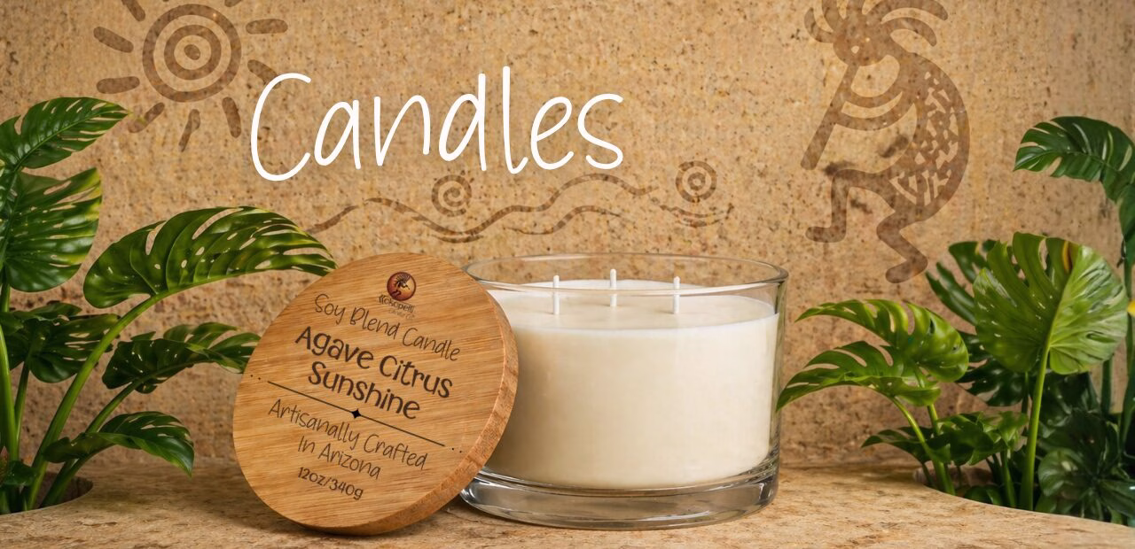 Agave Citrus Sunshine soy blend candle in a clear glass jar with wooden lid, set against a warm desert-inspired Kokopelli background with green tropical leaves.