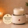 Agave Citrus Sunshine wickless soy candle warming on a ceramic candle warmer, featuring a clean white wax candle in a glass vessel with a warm ambient glow in a cozy home setting.